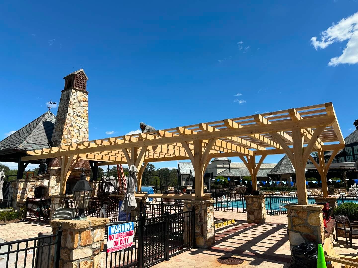 Heavy timber pergola over the pool deck at Brookhaven Country Club